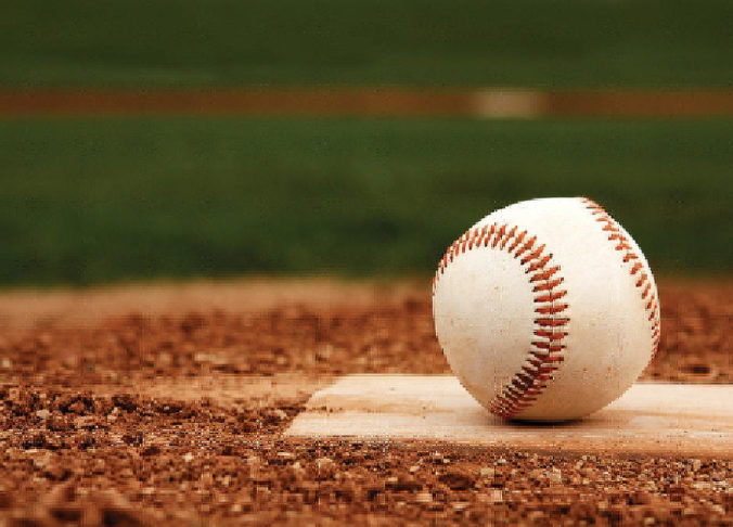 A close up photo of a baseball sitting on a baseball field.