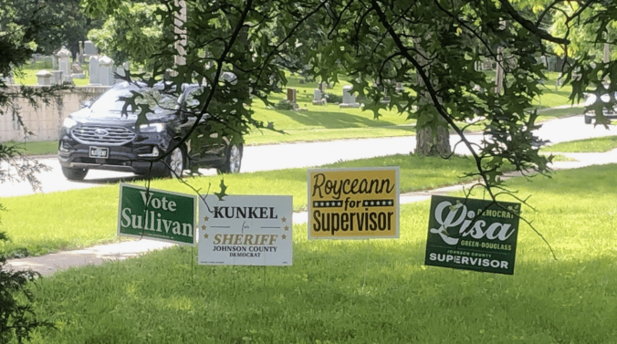 A photo of four signs for the Johnson County Iowa Democratic primary.
