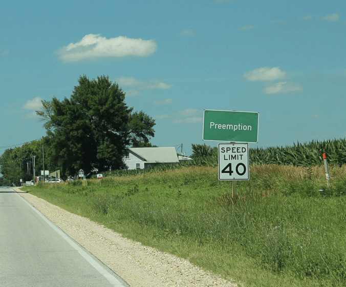 A highway road sign for entry into the town of Preemption, Illinois.